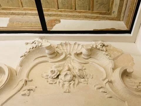 Il pannello di stucco sopra la porta, con il soffitto dipinto oltre il vetro
